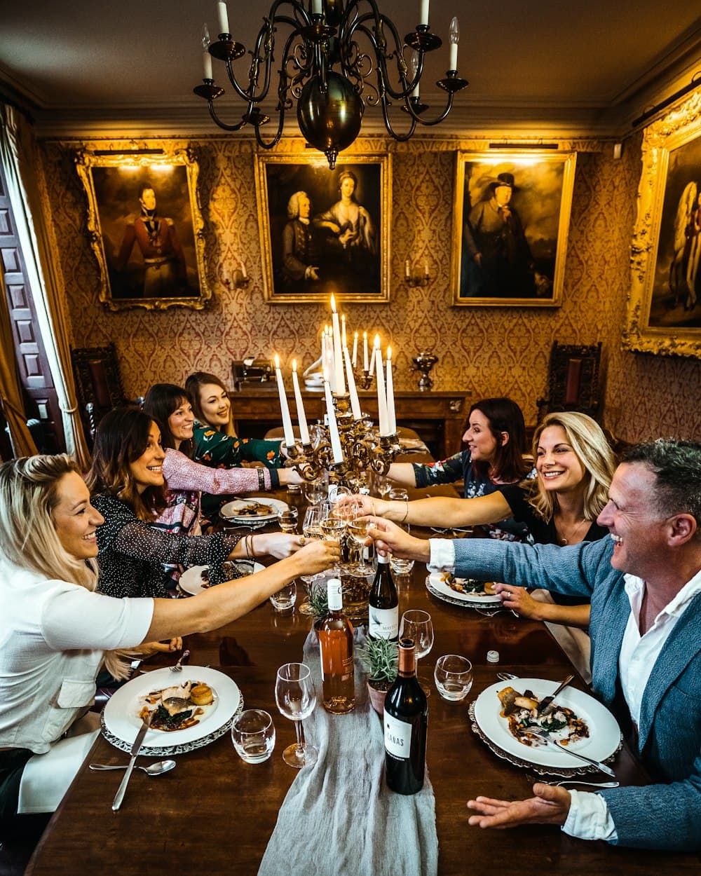 Een groep proost rond een prachtig gedekte dinertafel