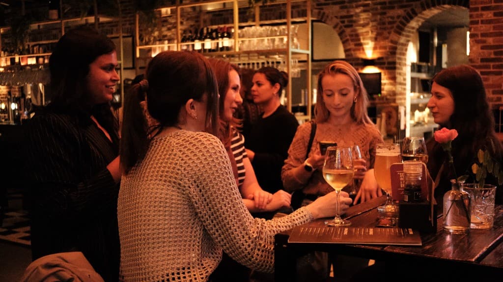 Een groep met een glas wijn in de hand, van locatie naar locatie